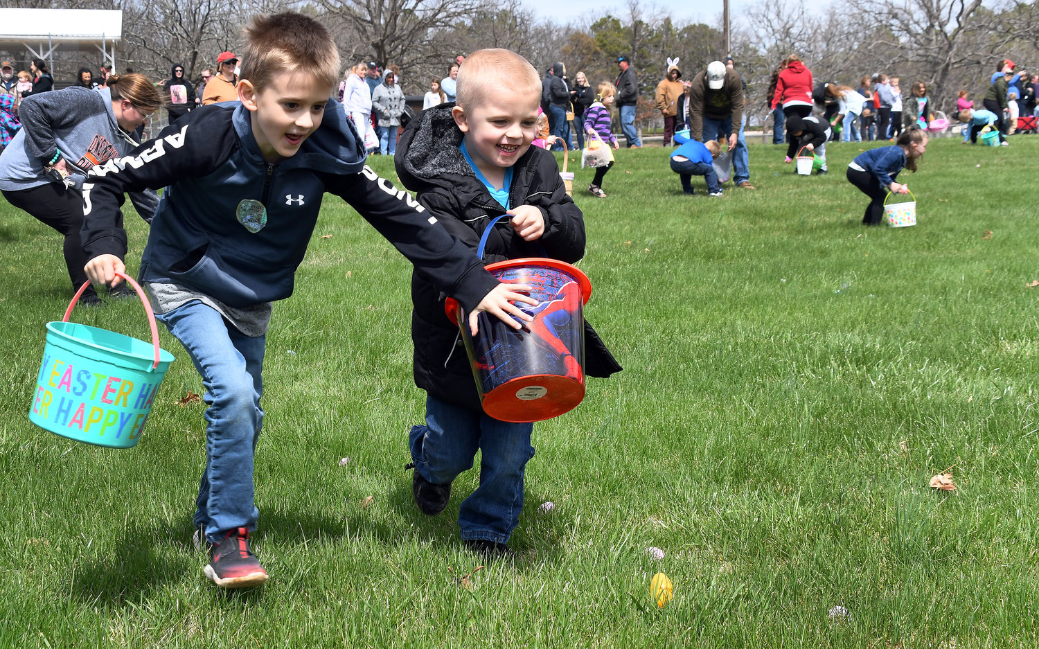 Volunteers filled 10,000 plastic eggs for the event which appears to have sparked some competition (left) as one egg hunter shields another from the group of eggs in front of them.